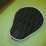 Custom harley bobber seat in black leather and white diamond stitching. For Cody.